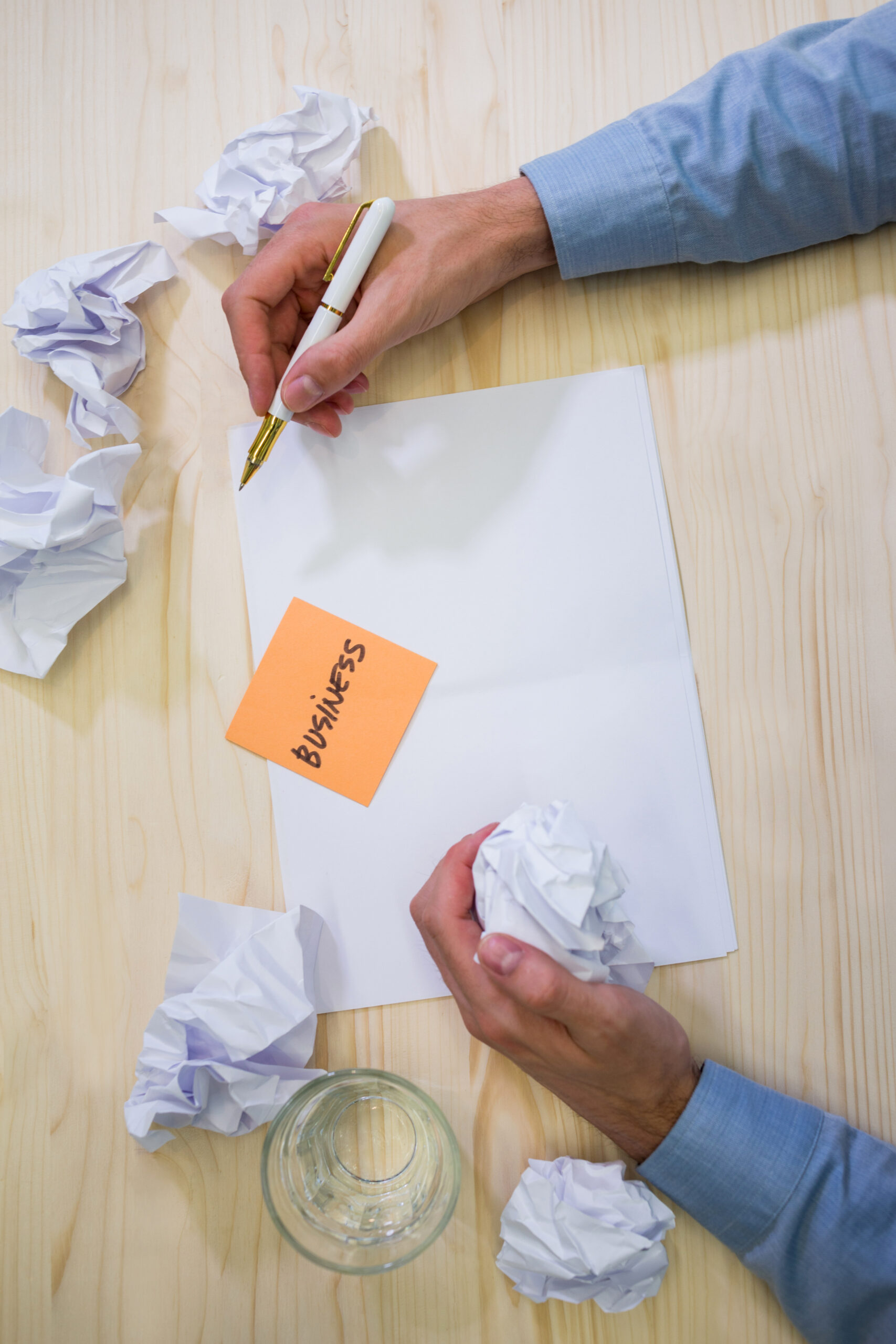hands of business executive holding crumpled paper and pen